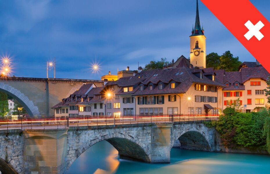 Brücke und Turm in Bern bei Nacht. In der Ecke rotes Banner Schweiz zum Thema Wohnmobil mieten Bern