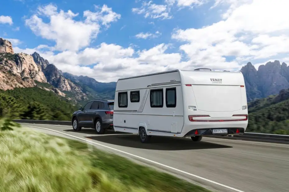 Wohnwagengespann von hinten bei einer Fahrt durch die Berge zum Thema Wohnwagen Miete in der Schweiz